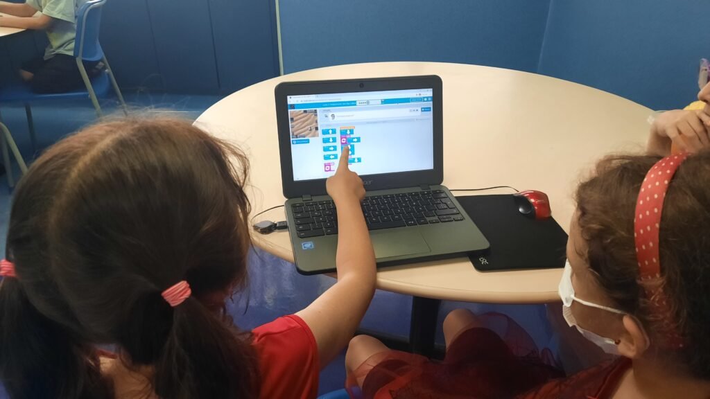 Crianças da DHEL programando em blocos no computador
